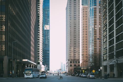Free Vibrant city street scene with tall skyscrapers and city life full of cars and pedestrians. Stock Photo