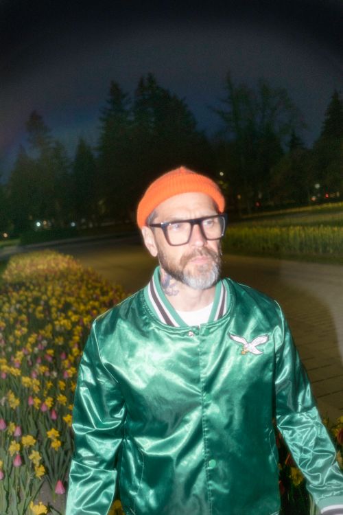 Free Stylish man in green jacket and orange cap, photographed at night in a park in Montréal. Stock Photo