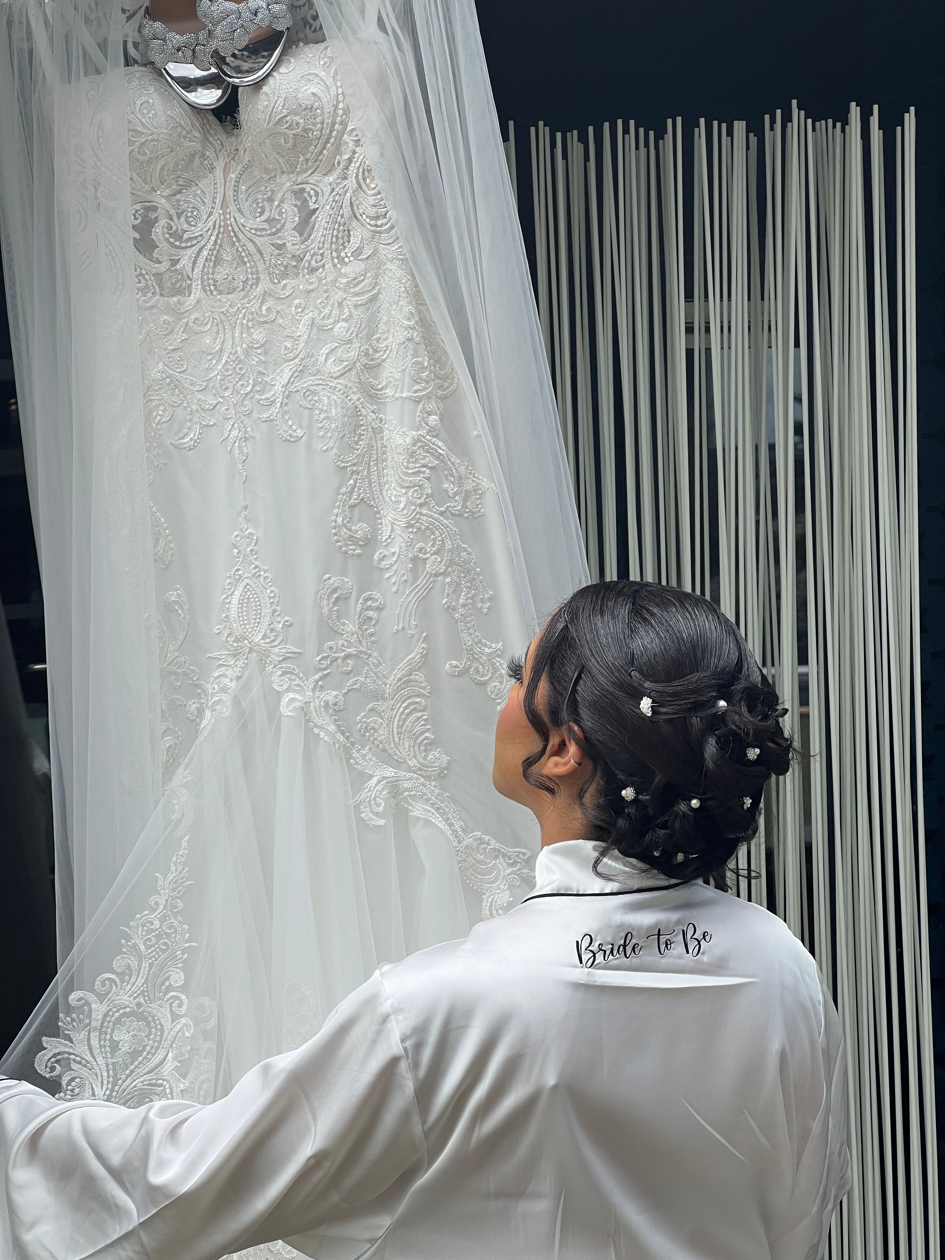 A bride admires a lace wedding dress, perfect for a luxurious and elegant wedding.
