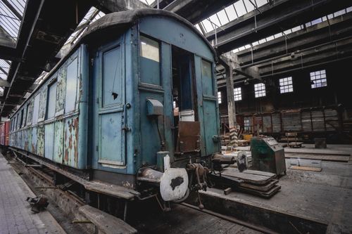 Free A vintage, rusting train car inside an old industrial warehouse, showcasing urban decay. Stock Photo