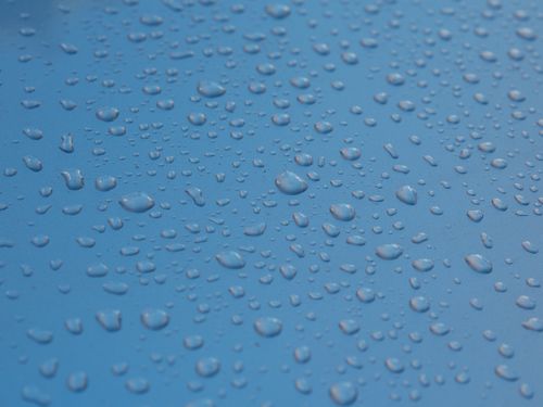 Free Close-up view of water droplets on a smooth blue surface, creating a refreshing texture. Stock Photo