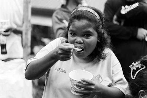 A Young Girl Eating on the Street