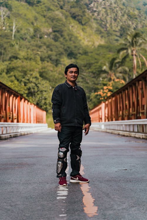 Man Standing on Bridge in Mountains Landscape