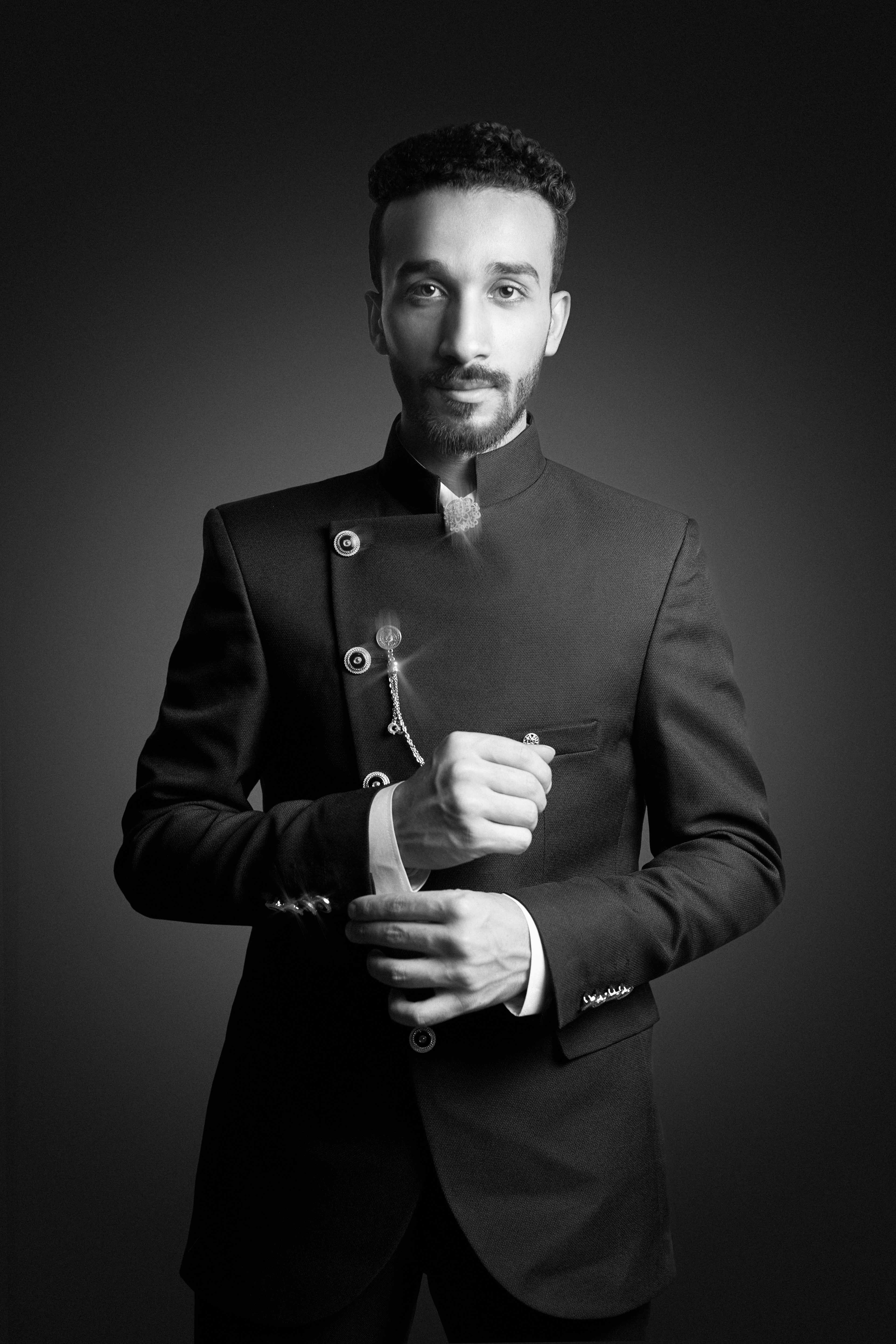 Stylish black and white portrait of a man in a modern suit, exuding confidence and elegance.