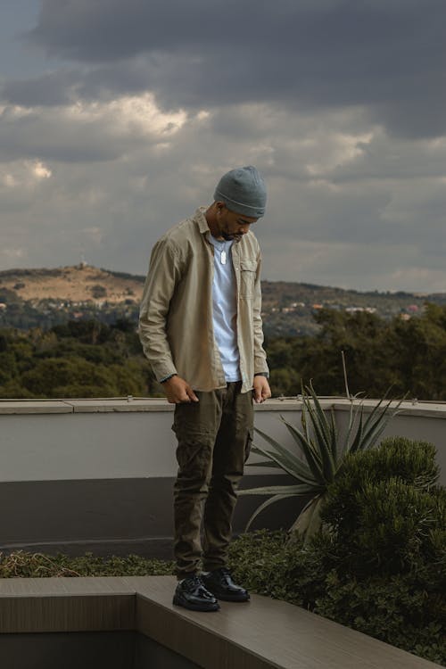 Young Man Standing on a Wall and Looking Down