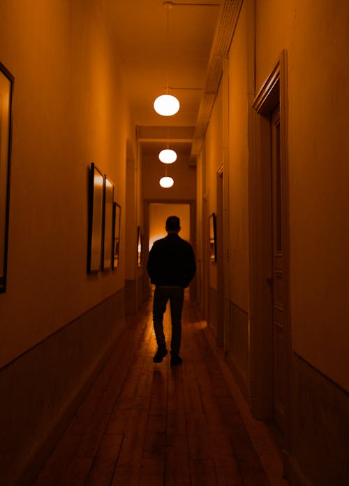 Man Walking in Corridor in Darkness