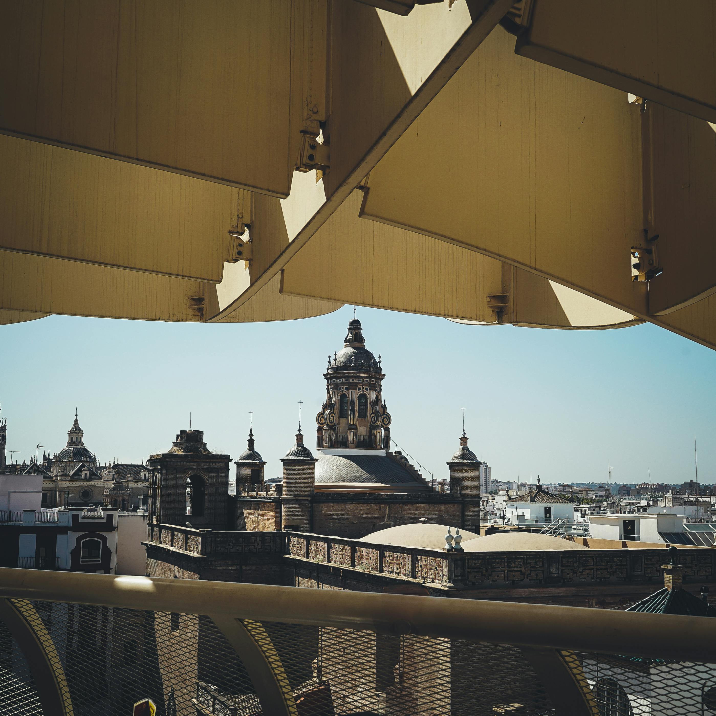 在蔚蓝的天空下，塞维利亚的景观以标志性的教堂圆顶和现代建筑为特色