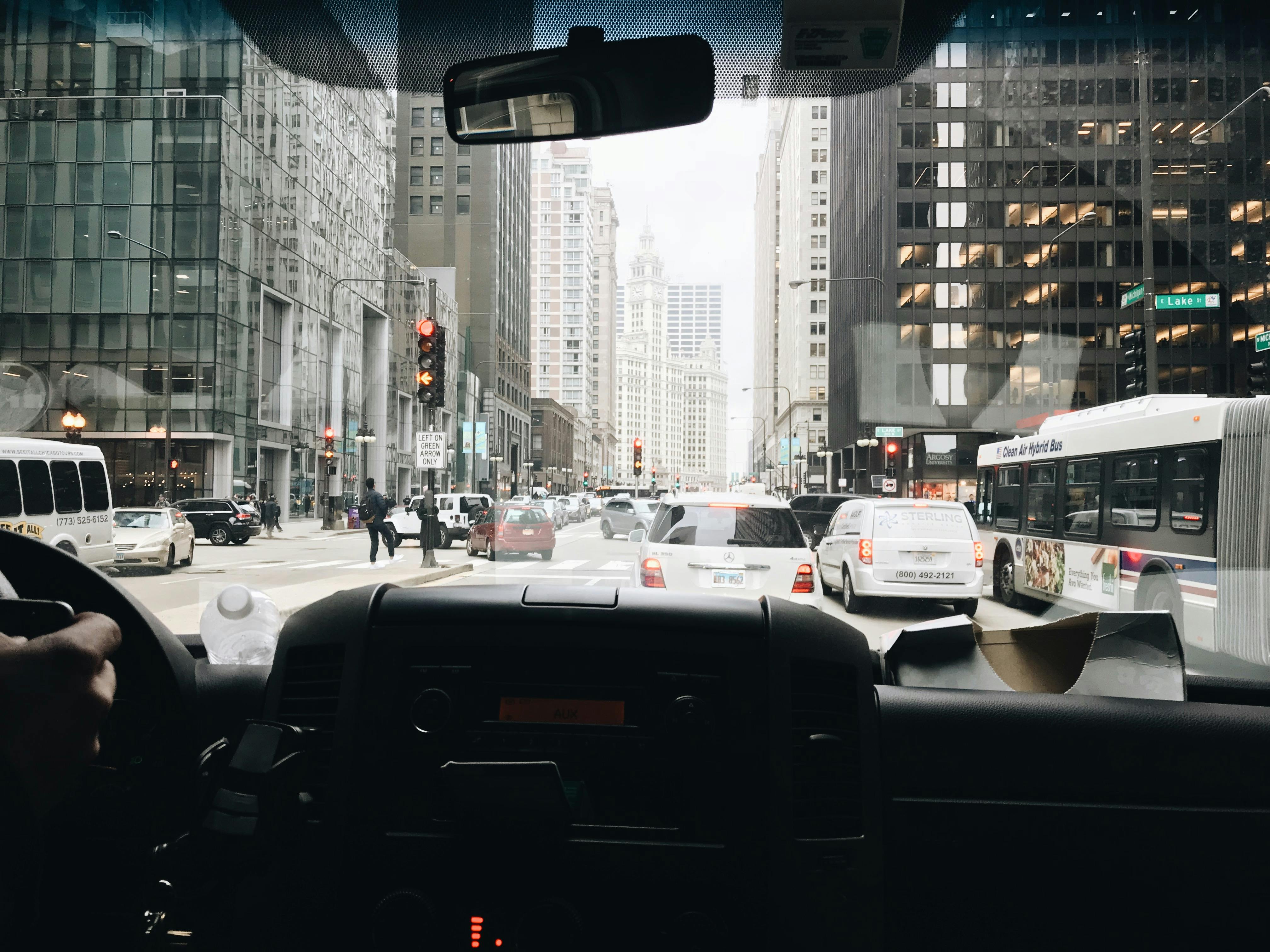 View of bustling Chicago street with traffic and skyscrapers from inside a vehicle.