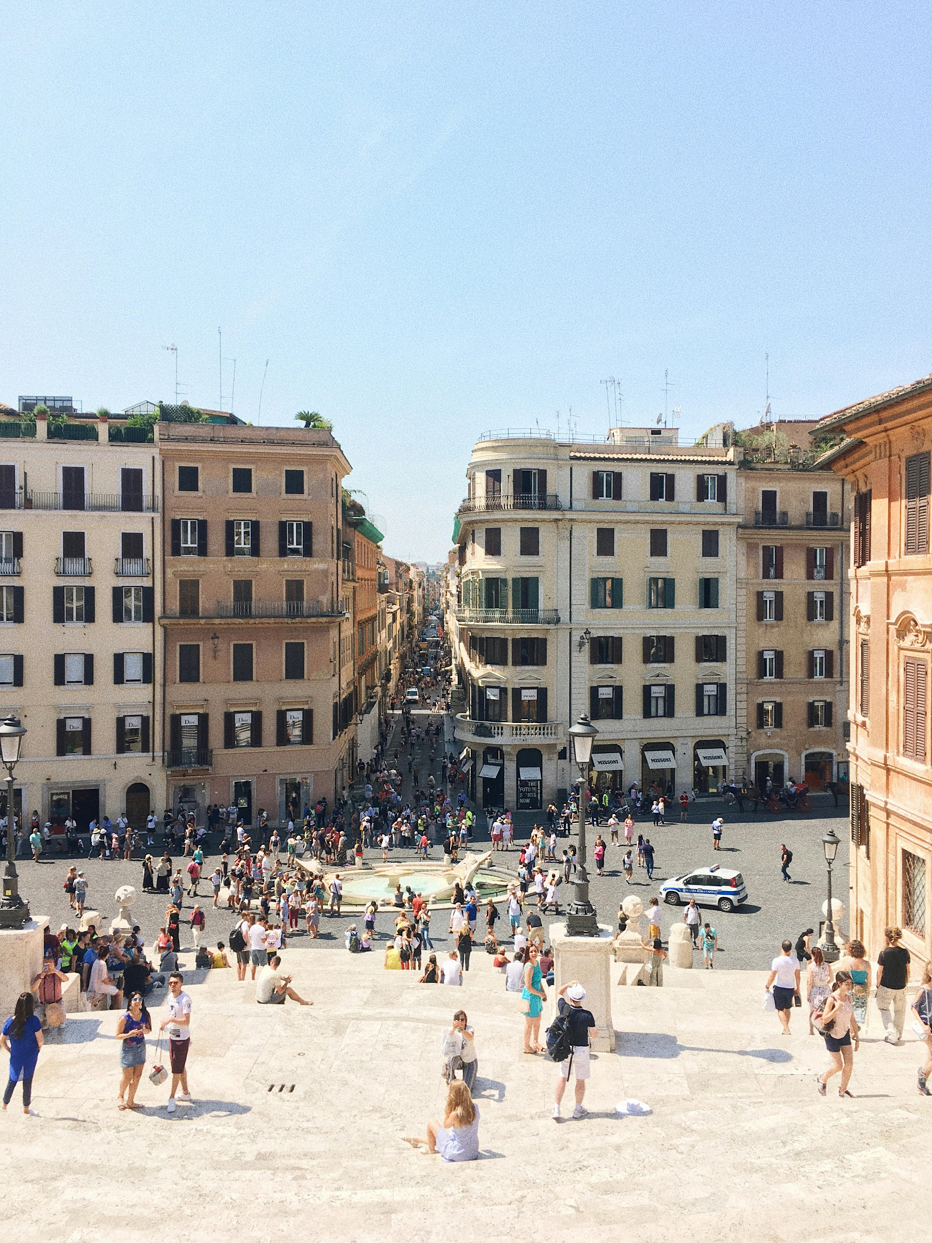 在意大利罗马的西班牙台阶上，人群正享受着阳光明媚的一天，捕捉着充满活力的城市景观