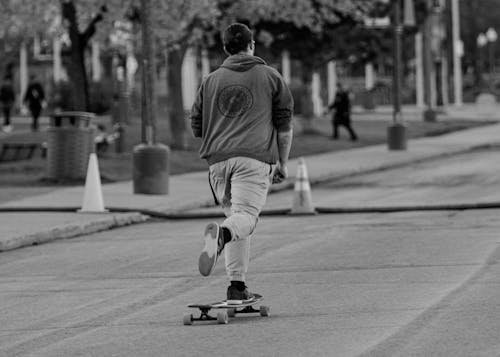 Back View of a Man on a Skateboard on the Street 