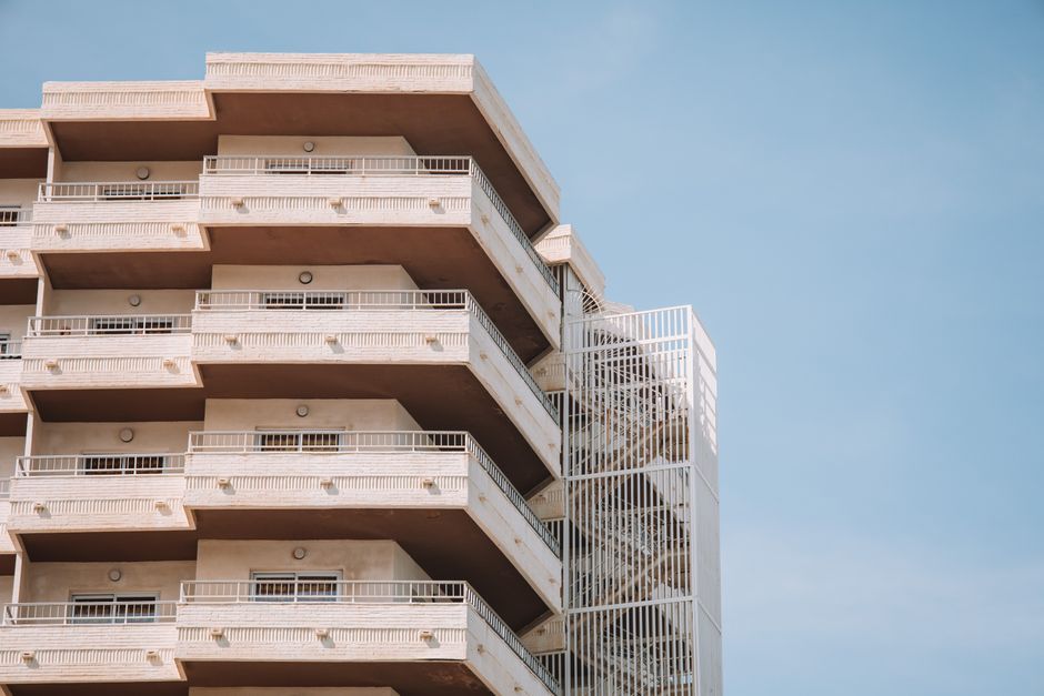 Vista en ángulo bajo de balcones modernos contra un cielo azul claro en Málaga, España.