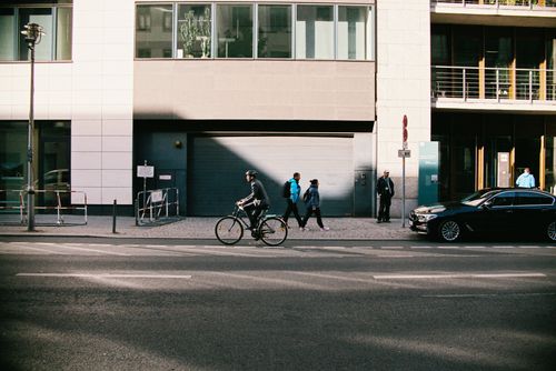 Free Cyclist and pedestrians in a typical urban street scene in Berlin, Germany. Stock Photo