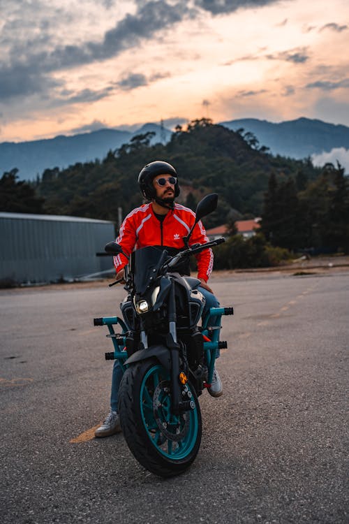 Man Sitting on a Motorcycle and Mountains in the Distance 