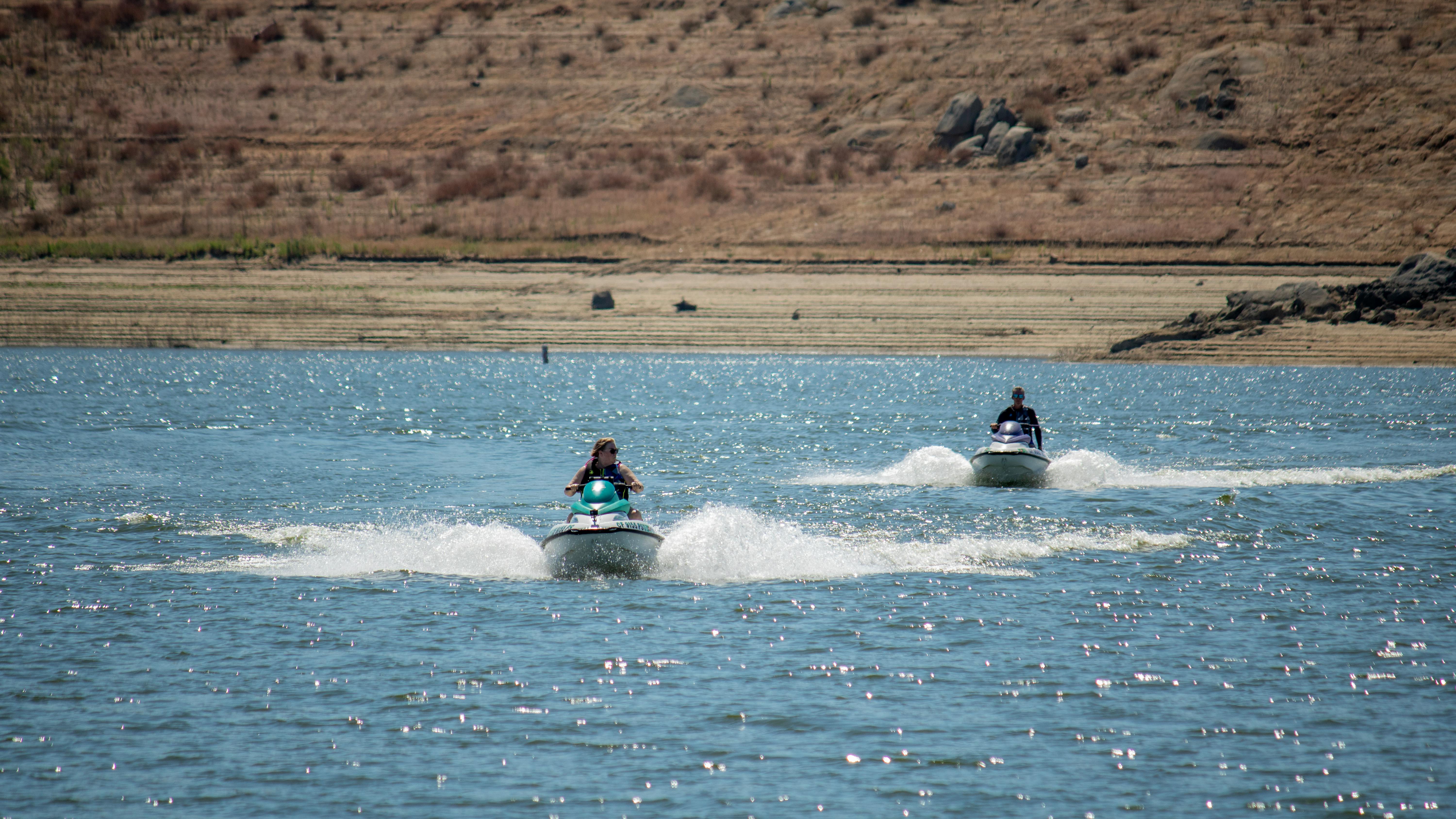 Prescription Goggle Inserts - Two people enjoy thrilling jet ski rides on a sunny lake, perfect for adventure.