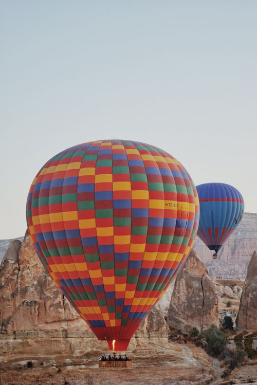 Free Vibrant hot air balloons soaring over unique rock formations under a clear sky. Stock Photo
