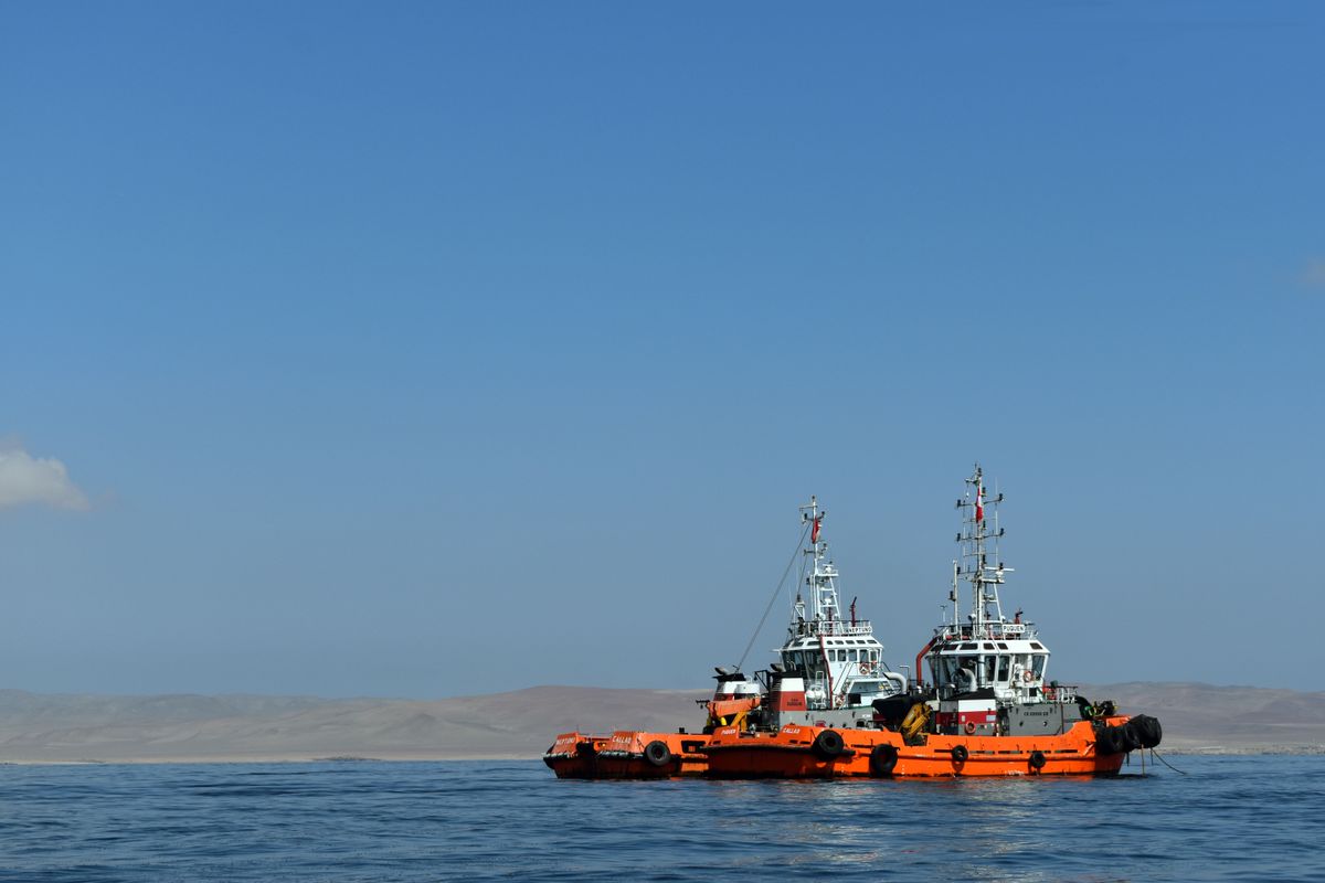 Two vessels navigating tranquil coastal waters