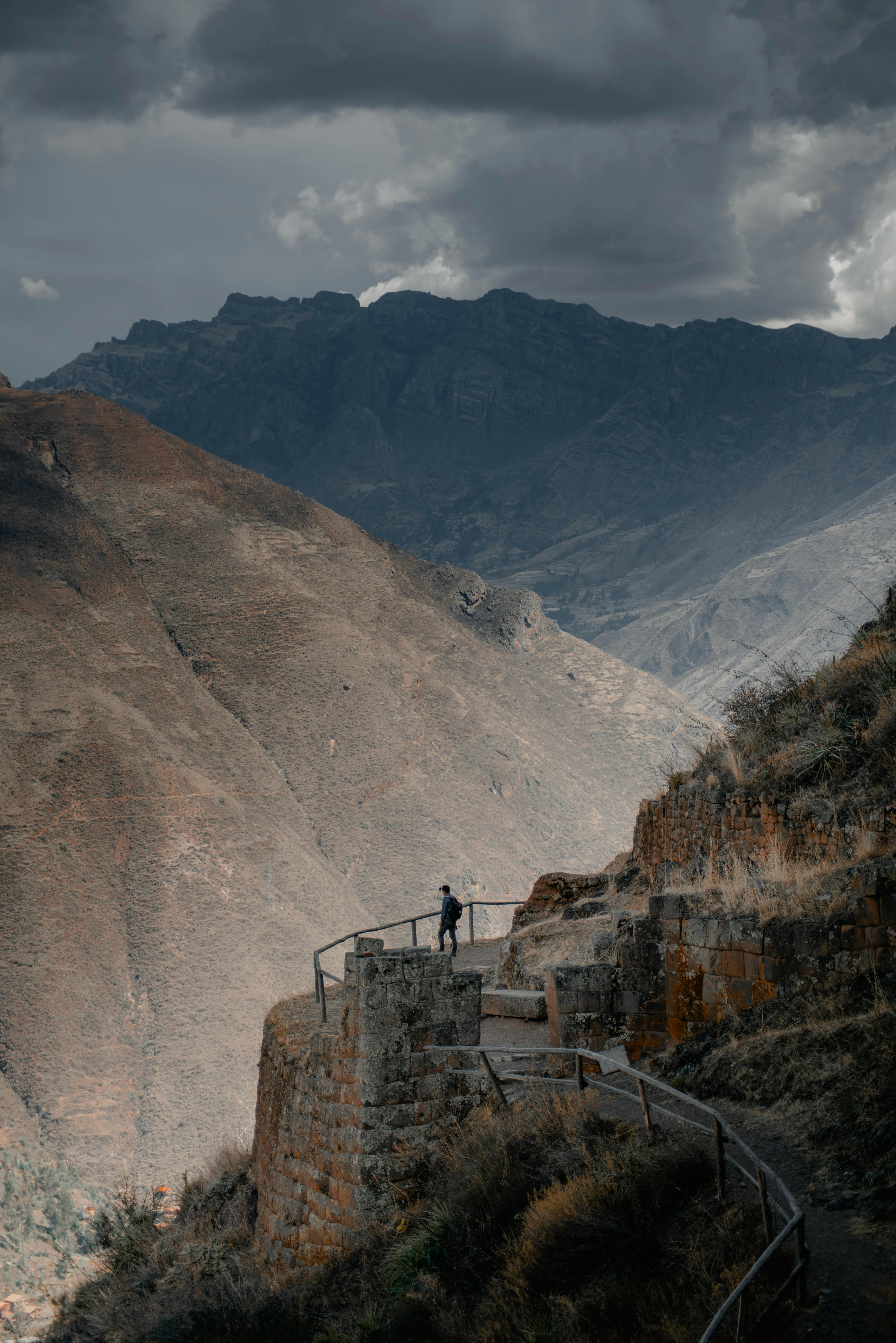 A breathtaking view of a trail through the mountains of Písac, Cusco, Peru with dramatic skies.