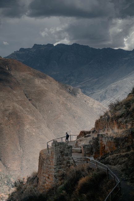 A breathtaking view of a trail through the mountains of P铆sac, Cusco, Peru with dramatic skies.