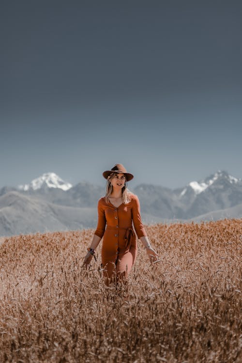 Blonde Woman with Hat in Dress Posing in Wheat Field