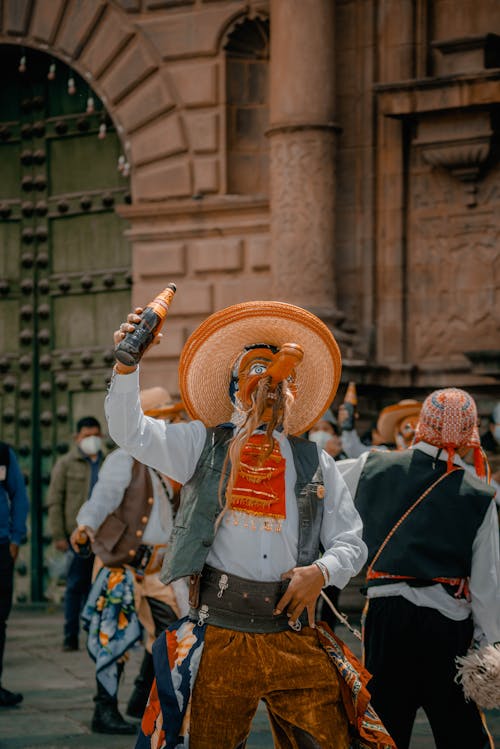 Man in Costume Standing with Bottle in Hand on Street in Peru