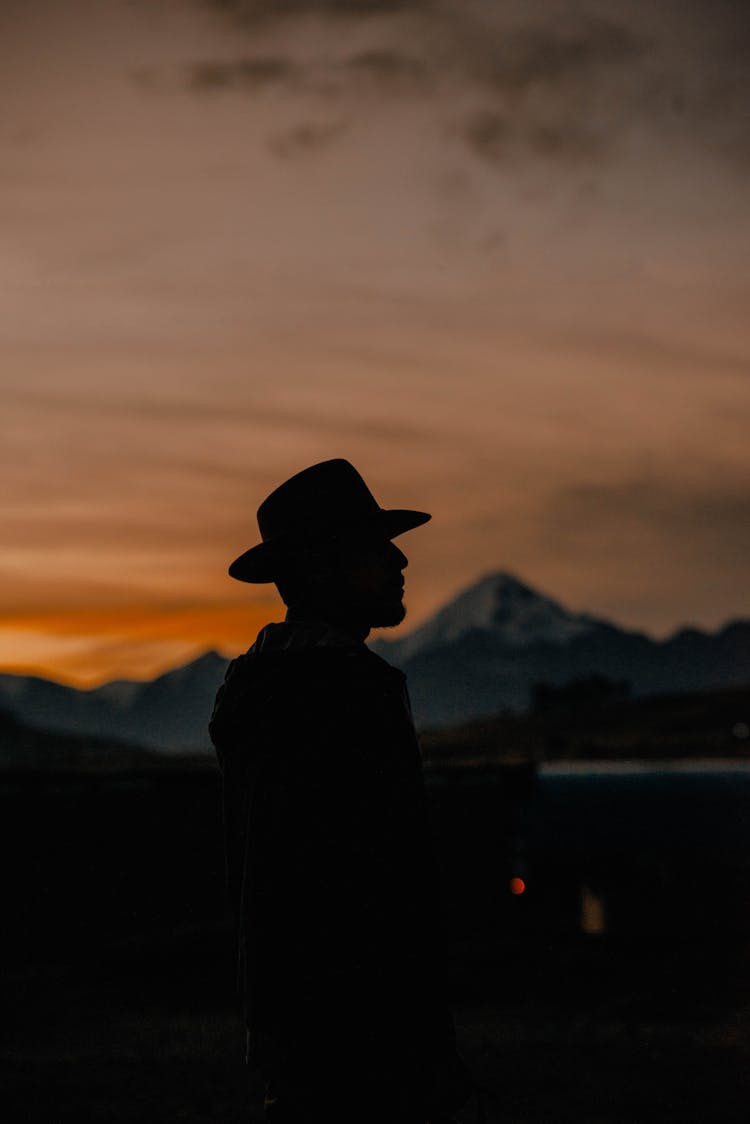 Silhouette Of Man In Hat At Sunset