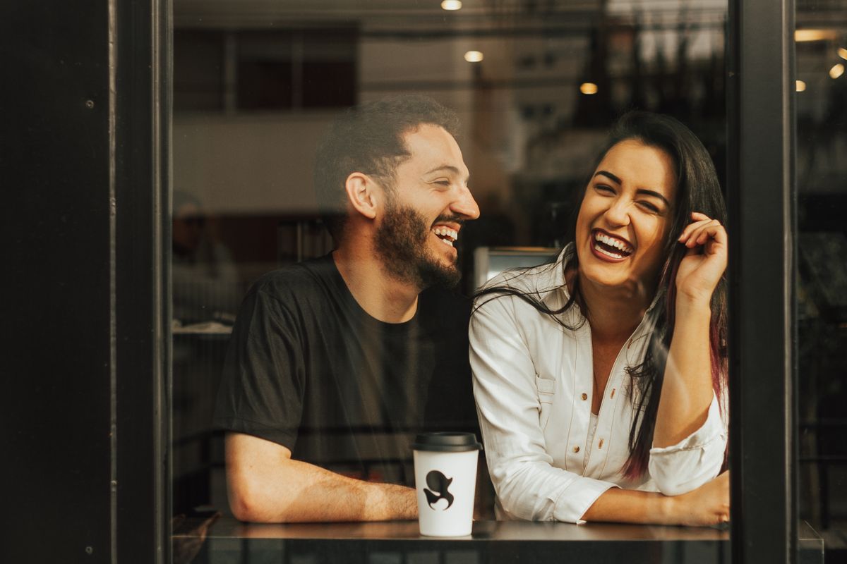Two people laughing together in a genuine, happy conversation