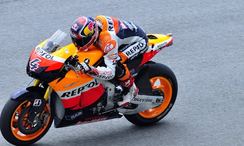 Free Man in Repsol Orange White and Blue Motorcycle Racing Gear Riding Sports Bike Stock Photo