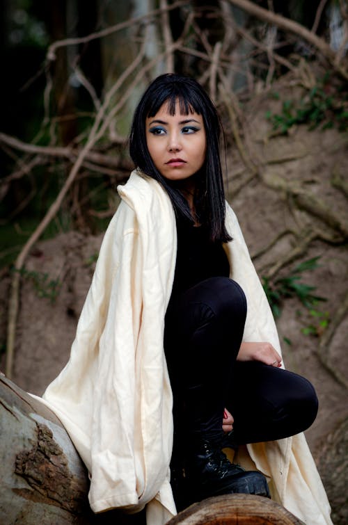 Young Woman in Forest with a Long White Coat Thrown Over Her Shoulders