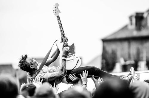 Free Gray Scale Photo of Man Lifted by People Holding Stratocaster Guitar Stock Photo