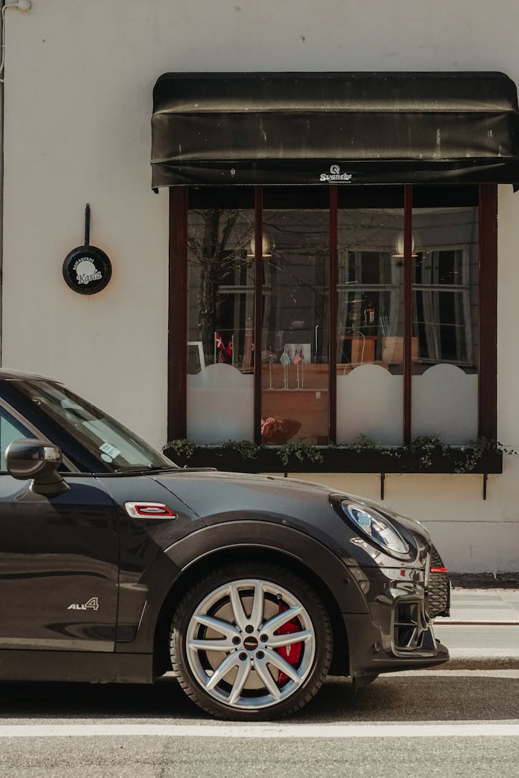 Photo Of A Car Parked In Front Of A Window In The City