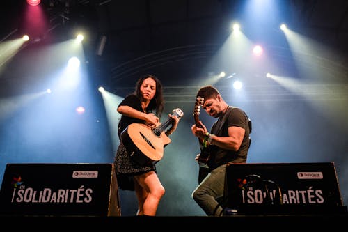 무료 남자와 여자 Solidarites에서 무대에서 기타를 연주 스톡 사진