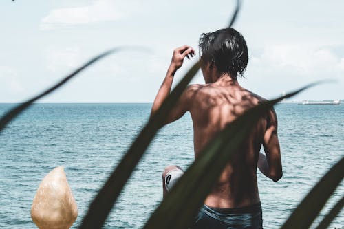 Photo of Shirtless Man Near Beach