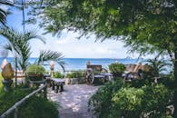 宁静的花园俯瞰着平静的海景，四周环绕着郁郁葱葱的绿植和质朴的长凳