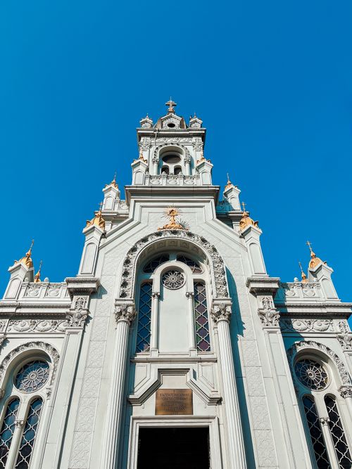 Free An exquisite baroque church facade showcasing ornate architectural details against a vibrant blue sky. Stock Photo
