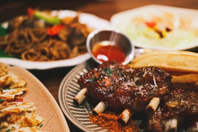 Close-up of a savory BBQ ribs platter with fries and dipping sauce, perfect for food enthusiasts.