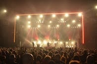 夜晚的现场音乐会气氛热烈，舞台上有乐队表演和灯光效果，观众热情高涨