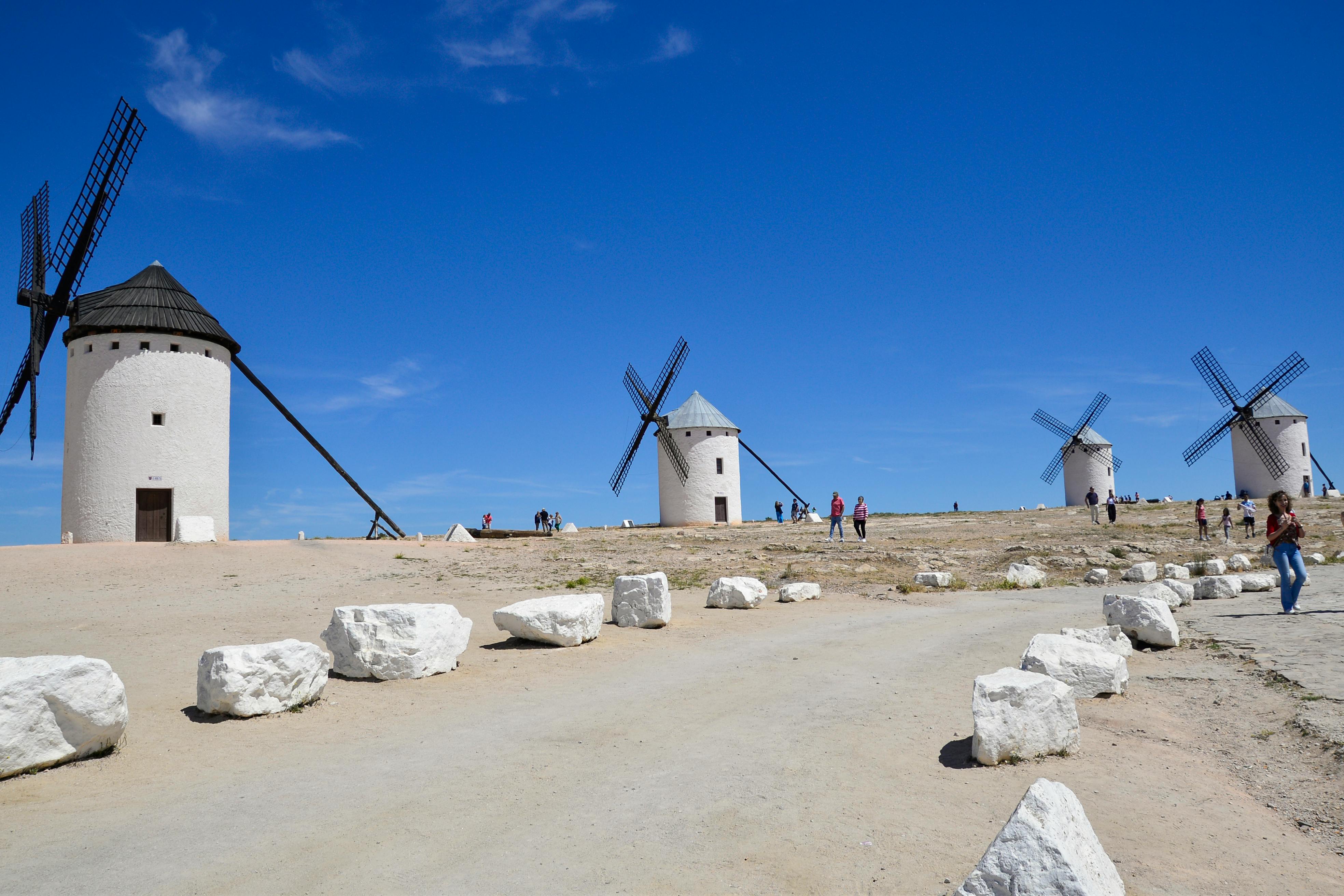 Sunlit windmills in Campo de Criptana, highlighting Spanish history and picturesque landscapes.