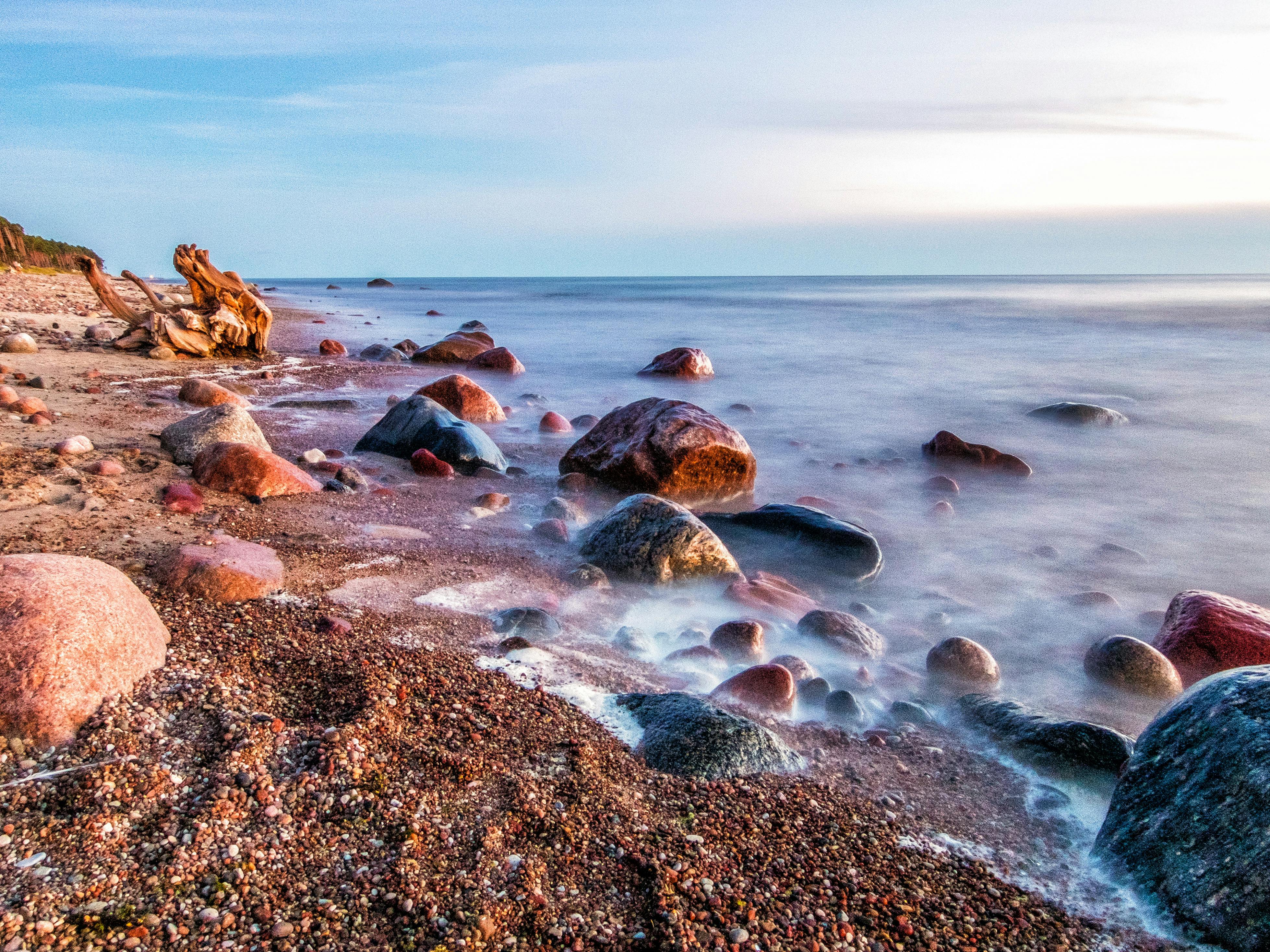 日落时分，平静的海浪映衬着宁静的海滩，岩石充满活力