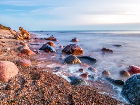 日落时分，平静的海浪映衬着宁静的海滩，岩石充满活力