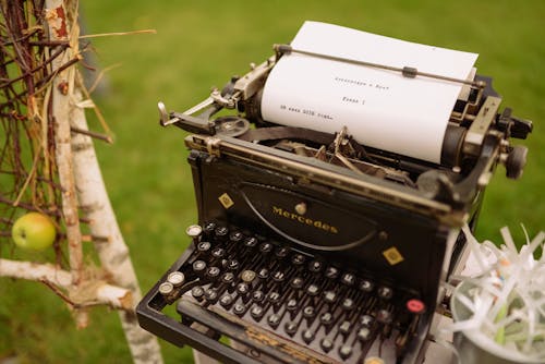 Black and White Typewriter on Green Grass Field