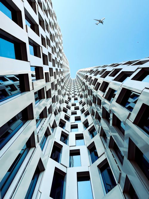 Free Stunning low angle capture of modern Berlin architecture with a plane overhead, highlighting urban design. Stock Photo