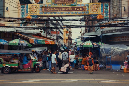 A lively street market bustling with vendors and pedestrians under colorful signage.