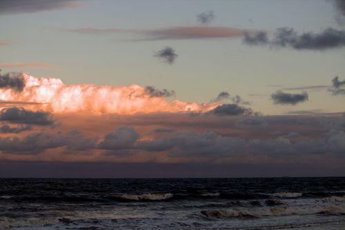 Free Beautiful sunset over Guaratuba Beach, capturing the vibrant colors and dramatic clouds. Stock Photo