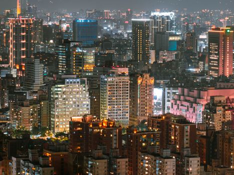 A stunning aerial view of a bustling cityscape illuminated at night with towering skyscrapers.
