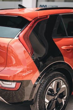 Red Niro sports car showcased in an urban environment, highlighting sleek design and style.