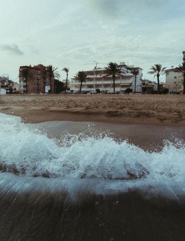Waves crashing onto a sandy beach in Barcelona, showcasing scenic coastal views.