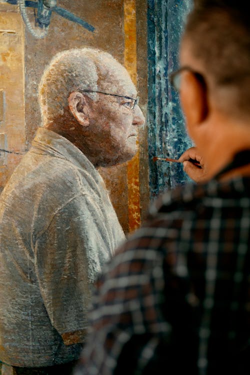 Photo of a Man Painting a Portrait
