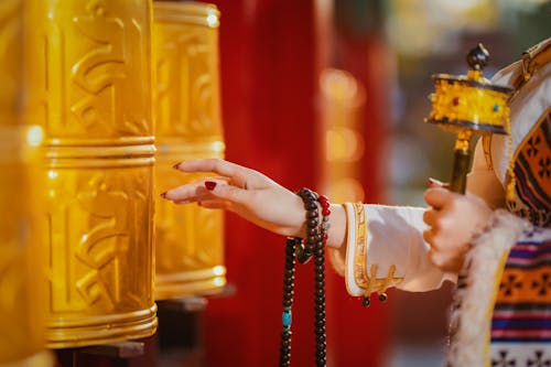 Woman Hand over Golden Buddhist Items