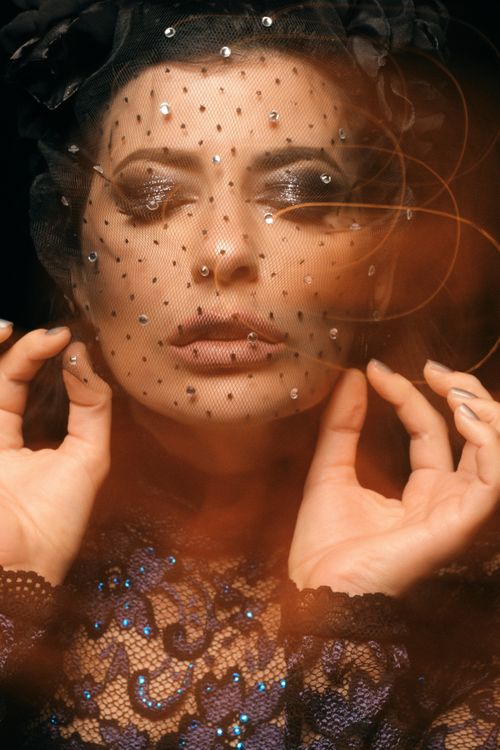 Free Creative portrait capturing a woman in a decorative veil with a blurred artistic effect. Stock Photo