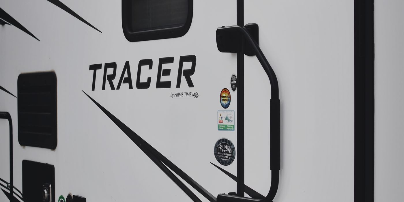 Close-up of the swoosh graphics and entry door on a travel trailer